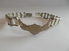 THIS IS A STERLING SILVER, HARLEY DAVIDSON  MEN'S, OR WOMANS BRACELET. THIS IS A LICENSED HARLEY DAVIDSON ITEM.  THE BRACELET MEASURES 8 1/2" LONG, AND WEIGHS A HEFTY  37.gm.  THIS BRACELET IS IN NICE CONDITION.  IT IS MARKED  925  FOR STERLING SILVER, AND ALSO MARKED MEXICO. THE PENDANT MEASURES  3/4" HIGH x 1 3/8" WIDE. THE CLASP WORKS FINE. A WORTHY GIFT. CHECK OUT MY HARLEY RINGS THAT I HAVE LISTED. THEY ARE NEW / OLD STOCK FROM THE 80's. PLEASE NOTE: I DO NOT CLEAN VINTAGE JEWELRY AS I LIKE Womans Bracelet, Harley Davidson Jewelry Woman, Biker Silver Skull Jewelry, Harley Davidson Jewelry, Motorcycle Chain Bracelet, Harley Davidson Men, Chain Link Bracelet, Link Bracelets, Sterling Silver Bracelets