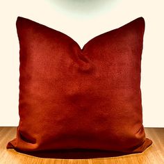 a red pillow sitting on top of a wooden table