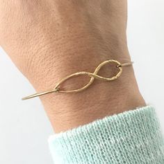 Description This infinity bracelet features a long twisted infinity symbol. It makes a great gift for brides, bridesmaids as a symbol for infinity love. Request a Custom Order Join more than 89 thousand delighted customers! - - - - - - - - - - - - - - - Sizing Pick from the easy size chart below or measure circumference of widest part of hand while reaching thumb toward pinkie to make hand narrow. Measure in this position since bangle slides over hand. All of my bangles are clasp-free, slide on Dainty Adjustable Bangle For Anniversary, Nickel-free Jewelry With A Modern Twist For Gifts, Infinity Jewelry For Mother's Day, Modern Twist Metal Jewelry As A Gift, Modern Twist Metal Jewelry For Gifts, Modern Twist Nickel-free Jewelry Gift, Modern Metal Jewelry As Gift, Modern Metal Jewelry Gift, Metal Bracelets For Wedding And Mother's Day