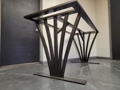 two metal sculptures sitting on top of a cement floor