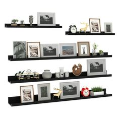 three black floating shelves with pictures and other items on them, each shelf has two different frames