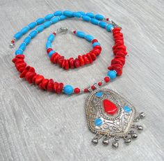 Red coral and Turquoise Southwestern necklace and bracelet set with Vintage Large silver enameled pendant. Necklace: The central part is a Vintage Tribal silver tone pendant made in India - textured pendant with turquoise blue and red enamel and 7 metal dangles. The necklace is made of natural red coral beads ( irregular shape ), blue turquoise howlite, round red pressed stone beads and silver plated diasy spacers. Bead size: - coral chips approximately 10 - 12 mm wide and 3 - 6 mm thick, - roun Red Jewelry Set, Green Agate Ring, Southwestern Necklace, Red Jewelry, Coral Jewelry, Turquoise Howlite, Blue Jewelry, Coral Beads, Country Western