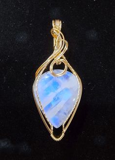 This moonlit beauty is a stunning Rainbow Moonstone with gorgeous adularescence.  A beautiful blue light mysteriously glows from within this gemstone.   The 33 carat natural Moonstone measures 23x26x7mm and is artfully handcrafted in 14K (14/20) yellow gold filled wire.  The pendant measures approximately 2 3/8 inches in length and 1 inch wide.  The bail is generously sized in order to accommodate a variety of chain widths. A handcrafted pendant and a unique and beautiful stone,  it is one of a kind. A gift box is included. Celestial Gemstone Jewelry Collectible, Mystical Moonstone Jewelry With Large Stone, Mystical Teardrop Gemstone Jewelry, Collectible Celestial Gemstone Jewelry, Unique Iridescent Moonstone Jewelry, Mystical Iridescent Moonstone Jewelry, Unique Collectible Moonstone Jewelry, Spiritual Moonstone Jewelry For Collectors, Blue Cabochon Moonstone Jewelry