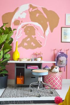 a pink and white wall with a large dog on it's face in the center