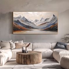 a living room with a large painting on the wall and a white couch in front of it