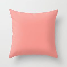 a pink pillow on a white wall with a light colored back ground and the top part of the pillow is slightly visible