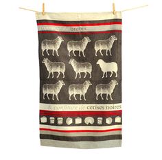 a tea towel with sheeps on it hanging from a clothes line against a white background