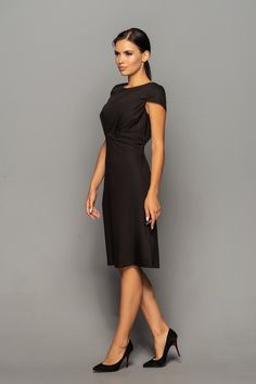 "A beautiful black origami dress featuring midi length, draped bodice, and cap sleeves. - draped origami top - boat neckline - cap sleeves - midi length - a-line silhouette - empire waist - side seam pockets - concealed back zipper closure Fiber: 50 % viscose, 45% polyester, 5% elastane Color: Black For size S: length- 40\"(101cm) Our model wears size S (US 8) and is 171cm/5'6\" tall. You may feel free choosing the size. Just send us your measurements (bust, waist, hips, height). We will define Little Black Dress Uk, Little Black Dress Wedding Guest, Little Black Dress Wedding, Black Dress Wedding Guest, Black Wedding Guest Dress, Black Dress Wedding, Black Wedding Guest, Empire Waist Dresses, Black Wedding Guest Dresses