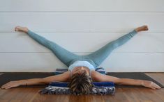 a woman is laying on her back in a yoga position with one leg up and the other hand behind her head