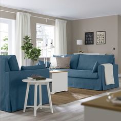 a living room filled with furniture and a white table in front of a blue couch