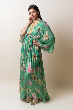 Green chiffon kaftan dress with floral print and sequins hand embroidered placket and neckline. Comes with an inner.
Components: 2
Pattern: Printed, Hand embroidered
Type Of Work: Floral, Sequins
Neckline: V Neck
Sleeve Type: Flared Sleeves
Fabric: Chiffon
Color: Green
Other Details: 
Length : Dress - 57 inches
Occasion: Party - Aza Fashions Bollywood Style Sequined V-neck Dress, Bollywood V-neck Sequin Dress, Flowy Bohemian Silk Chiffon Maxi Dress, V-neck Floral Print Dress For Eid, Summer V-neck Chiffon Kaftan, Floral Print V-neck Kaftan For Party, Spring Party Kaftan With Kimono Sleeves, Evening Kaftan With Floral Embroidery, Silk Chiffon Maxi Dress For Beach