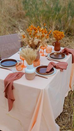 the table is set with plates and vases