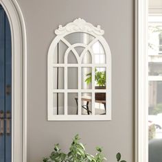 a potted plant sitting on top of a wooden table next to a white window