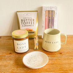 the contents of a coffee cup and saucer on a wooden table next to other items