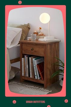 a wooden night stand with books on it and a lamp next to the end table