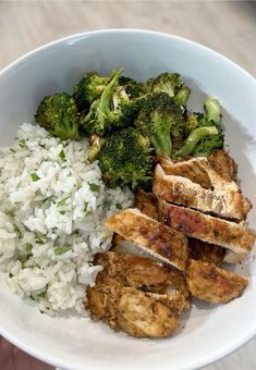 a white bowl filled with rice, meat and broccoli