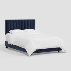 a bed with white sheets and blue velvet headboard on it's side, in front of a gray background