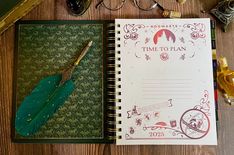 an open notebook with a feather quill sitting on top of it next to other items