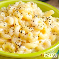 a green bowl filled with macaroni and cheese