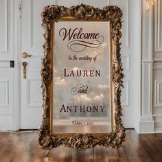 a welcome sign in front of a white door with lights on the wall behind it