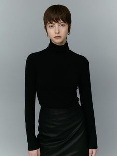 This is a turtleneck top with full-length sleeves, designed for a sleek and fitted look. The neckline is high and folds over, typical of a turtleneck style, which can provide warmth and a sophisticated appearance. The fabric appears smooth and possibly has some stretch, which would allow a close fit to the body.- The turtleneck's structure is ideal for cooler weather and can be used as a layering piece under jackets or sweaters.- Its overall design is minimalist, with no visible patterns or embellishments, offering a clean and versatile look.- The tailored fit and simple elegance make it a suitable choice for both casual and more formal settings. Innovative Materials, Turtleneck Style, Refined Aesthetic, Turtleneck Top, Ykk Zipper, Cooler Weather, Turtle Neck Top, Simple Elegance, Everyday Essentials