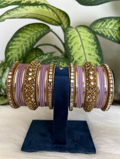 The perfect accessory for your special occasions, these pastel purple and Golden Color Bangles feature Kundan and Stone detailing. Crafted with copper, these bangles are sure to add a touch of elegance and glamour to your look. Features: * Copper material *  kundan  detailing * pastel purple and Golden Color * Size: 2.6,2.8,2.10 Purple Bangle Jewelry For Wedding, Purple Bangle For Wedding, Traditional Adjustable Purple Bangle, Elegant Adjustable Purple Bangle, Festive Purple Bangle, Traditional Purple Bangle For Festive Occasions, Traditional Purple Bangle Bracelets, Traditional Purple Bracelets For Festive Occasions, Traditional Purple Bracelet For Festive Occasions