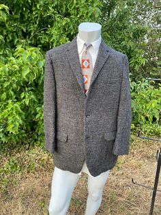 This is a 1950s hand woven Harris Tweed sport jacket in a drab grey and red. The Union label in its pocket dates this from 1949-1962. Th lining is fully intact and there are no holes in any of the pockets. All original buttons are present. Though there may be some small flaws due to its 60 year age.  JACKET Shoulders seam to seam: 18" Sleeve from seam to cuff: 23.5" Top to bottom: 32.5" Under arm to under arm: 23" Lapel width: 2.5" Like the tie? listed here: https://www.etsy.com/listing/17260794 Vintage Tweed Jacket With Lapel Collar And Pockets, Retro Tailored Tweed Blazer, Vintage Tailored Tweed Jacket, Retro Tailored Single Breasted Tweed Jacket, Tailored Retro Tweed Blazer, Retro Tweed Outerwear For Business, Retro Tweed Single-breasted Outerwear, Vintage Tweed Jacket For Fall Semi-formal Events, Gray Tweed Jacket With Welt Pockets For Fall