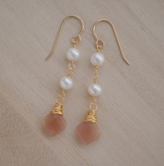 Add a subtle touch of elegance to your look with these beautiful Peach Moonstone and Freshwater Pearl dangle earrings. With their warm, peachy tones and soft pearls, these earrings feel inviting and calming and are perfect for weddings or special occassions.Peach Moonstone is known for aiding in the release of negative thinking and being overly self-critical. It's believed to be a stone of new beginnings, that brings balance and relief from emotional issues. The matching necklace is here.GEMSTON Elegant Apricot Dangle Earrings, Elegant Apricot Dangle Jewelry, Handmade Apricot Earrings In Elegant Style, Handmade Apricot Earrings Elegant Style, Handmade Elegant Apricot Earrings, Sunstone Earrings, Pearl Earrings Handmade, Natural Gemstone Necklace, Beaded Earrings Tutorials