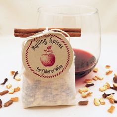 a bag of cinnamon sticks next to a wine glass filled with mulling spice for cider or wine