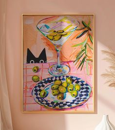 a painting hanging on the wall next to a vase with fruit in it and two cats