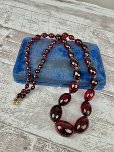 Antique 1920s 1930s Graduated Cherry Amber Bakelite Bead Necklace Hand Knotted Silk Cord. Here we have an authentic 1920s or 30s necklace. It is made from graduated cherry amber colored bakelite beads. The beads are strung on a hand knotted silk cord that is a red color. It has a gold toned spring ring clasp for closure. Measurements in inches:  Length: 30" Width: .75" (largest), .25" (smallest) Weight: 26.70 ounces (75.7 grams) Please take a moment to view all of the photos and check out our li Vintage Formal Beaded Necklaces With Polished Beads, Vintage Formal Beaded Necklace With Polished Beads, Vintage Beaded Necklaces For Formal Occasions, Vintage Jewelry With Polished Oval Beads, Vintage Formal Necklaces With Polished Beads, Vintage Polished Beads Necklaces For Formal Occasions, Vintage Polished Beads Necklace For Formal Occasions, Vintage Amber Beaded Necklaces, Vintage Single Strand Beads For Formal Occasions