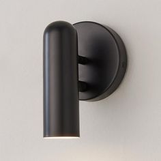 an image of a black wall light that is on the side of a building with white walls