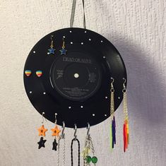 a clock made out of a record with charms hanging from it