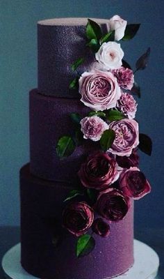 a three tiered purple cake with flowers on top