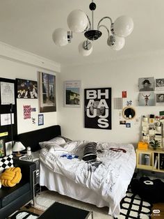 a bed room with a neatly made bed and lots of pictures on the wall above it