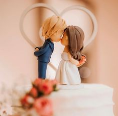 a wedding cake topper with a bride and groom kissing