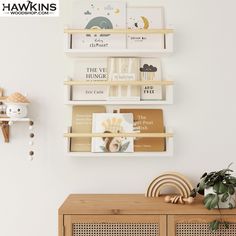 a shelf with books on it next to a potted plant and other items in front of a white wall