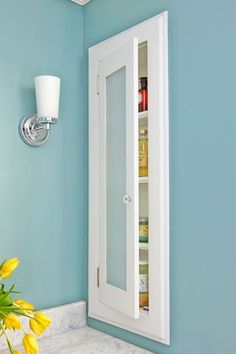 a bathroom with blue walls and yellow flowers in the vase on the counter next to the mirror