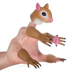 a hand holding a small toy animal in it's right arm, with one foot on the ground