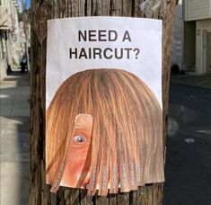 a sign on a telephone pole that says need a haircut? with an image of a woman's head