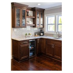 a kitchen with wooden cabinets and white marble counter tops, along with a wine cooler