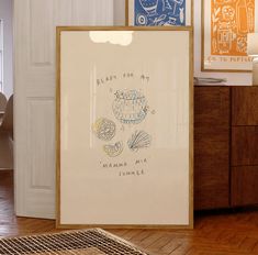 two framed art pieces sitting on top of a hard wood floor next to a dresser