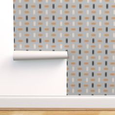 a wall with a pattern on it and a roll of paper in front of it