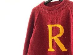 a red sweater with the letter r on it