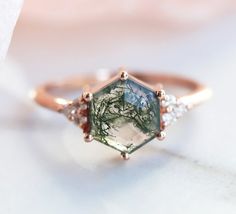 a close up view of a ring with a green and white stone in the center