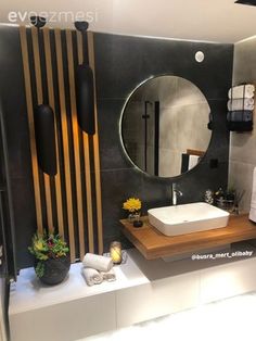 a bathroom with a sink, mirror and towel rack on the counter in front of it