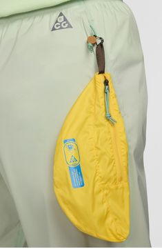 Long, blustery hikes are no match for the unparalleled functionality of these lightweight and packable ripstop pants boasting a waterproof finish and fully seam-sealed construction. A banana-shaped pocket pouch that pulls out is perfect for stashing snacks or small valuables. 28" inseam; 12" leg opening; 12" front rise; 15 1/2" back rise (size Medium) Elastic waist Front zip pockets; pull-out pocket pouch Storm-FIT ADV windproof and waterproof fabric plus seam-sealed construction keeps you comfo Nylon Parachute Pants With Functional Drawstring For Outdoor, Nylon Techwear Parachute Pants For Outdoor Activities, Nylon Techwear Parachute Pants For Outdoor, Techwear Pants With Reflective Details For Outdoor, Functional Outdoor Bottoms With Reflective Details, Nike Green Bottoms For Outdoor Activities, Nike Green Bottoms For Outdoor, Nike Outdoor Pants With Side Pockets, Sporty Parachute Pants With Functional Drawstring For Outdoor