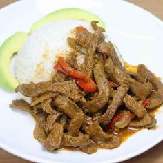 a white plate topped with meat and rice