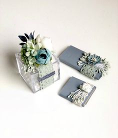 three pieces of paper with flowers in them sitting on a table next to each other