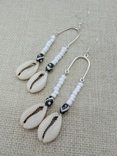 The earrings are handmade beaded and light weight. The earrings are beaded with cowrie shells, glass and ethnic beads. The earrings are 3.5 inches long. If you have any questions please feel free to contact us at anytime. All shipping options are available. All items will be shipped out Monday through Friday. Receipts will be emailed out for immediate access. All items will be shipped out carefully and every shipment can be made with extra insurance upon request. All other concerns and details can be found in our policy section. Our goal is for your 100% satisfaction. If you would like to make a large order please contact us for a coupon code. Our products are not intended for babies or children as we use small pieces, wires and beads. These can be dangerous to them when unsupervised. Gift Bohemian Beaded Earrings For Vacation, Bohemian Silver Beads Jewelry For Beach, Bohemian White Earrings For Beach, Beach Heishi Beaded Earrings, Handmade White Heishi Beads Earrings, Colorful Beaded Earrings For The Beach, Bohemian Shell Beaded Earrings, Bohemian Beaded Dangling Earrings For Vacation, Handmade White Beaded Earrings For Vacation